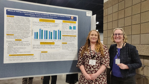 Simone Schnall and Emily McKendrick standing in front of poster at SPSP conference