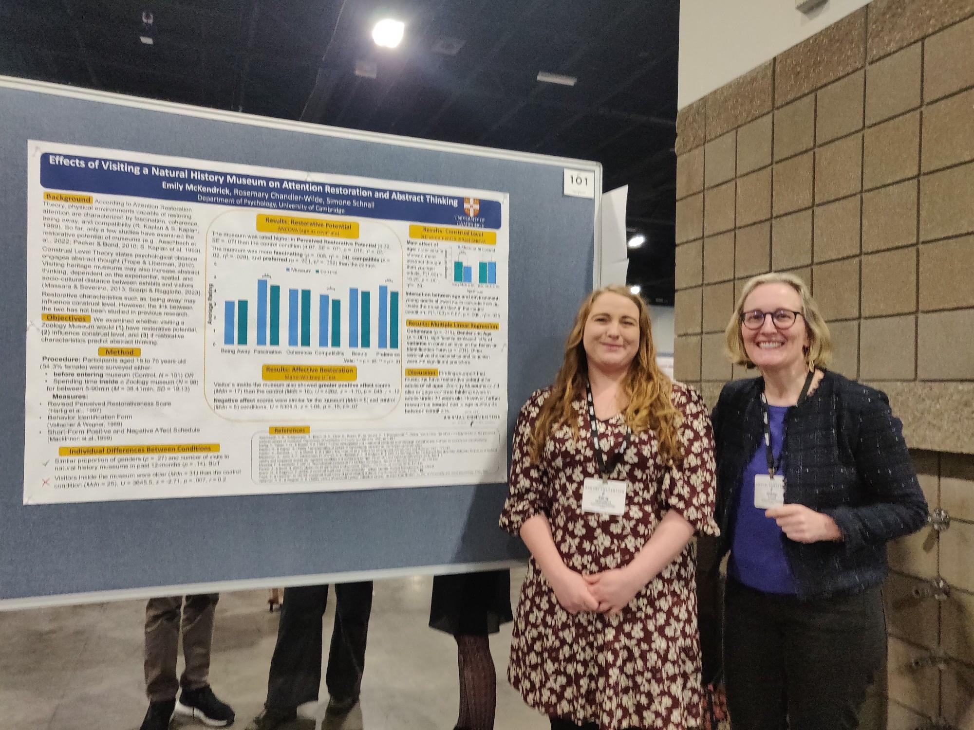 Simone Schnall and Emily McKendrick standing in front of poster at SPSP conference